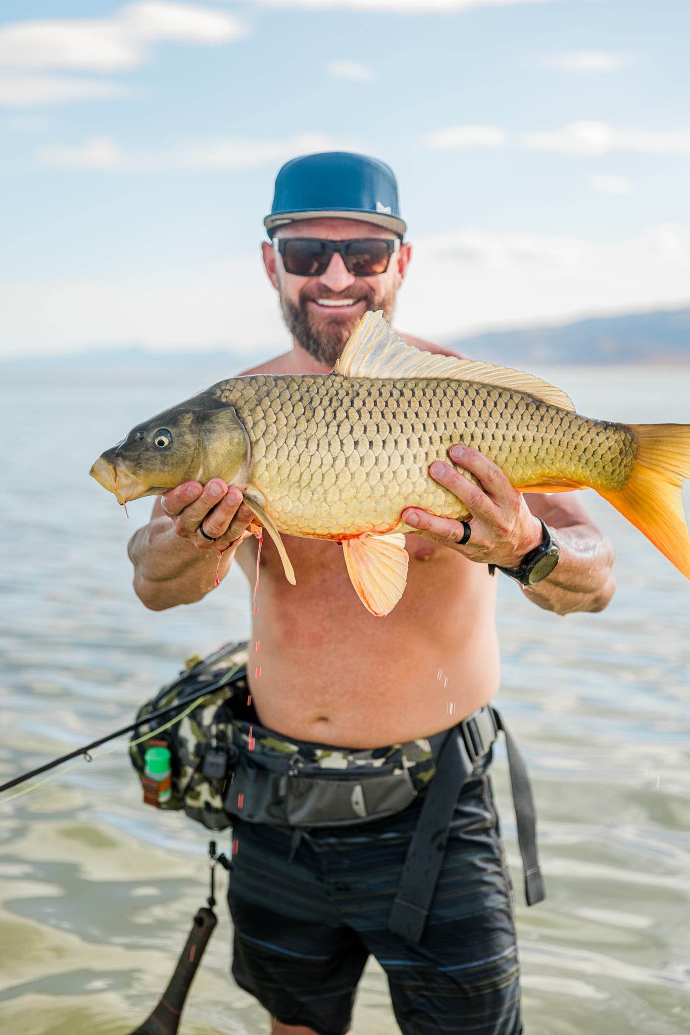 Matt Smith holding a large carp on a Utah lake — the kind of day the Men's Experience is built around