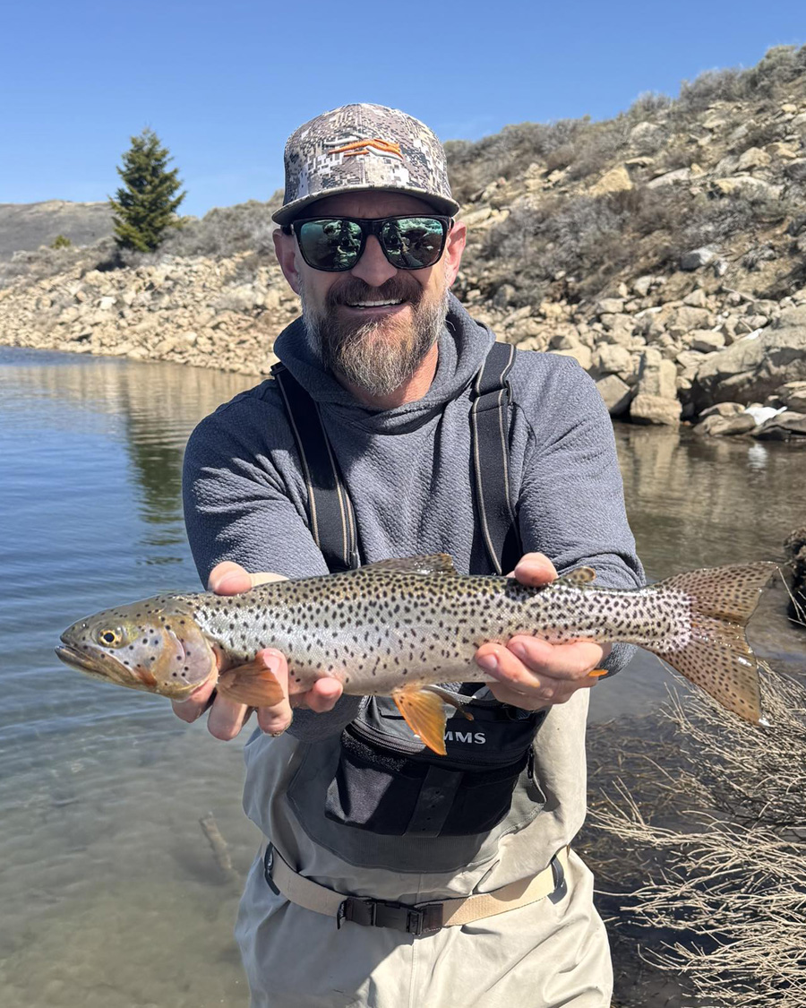 Matt Smith holding a brown trout on a Utah river